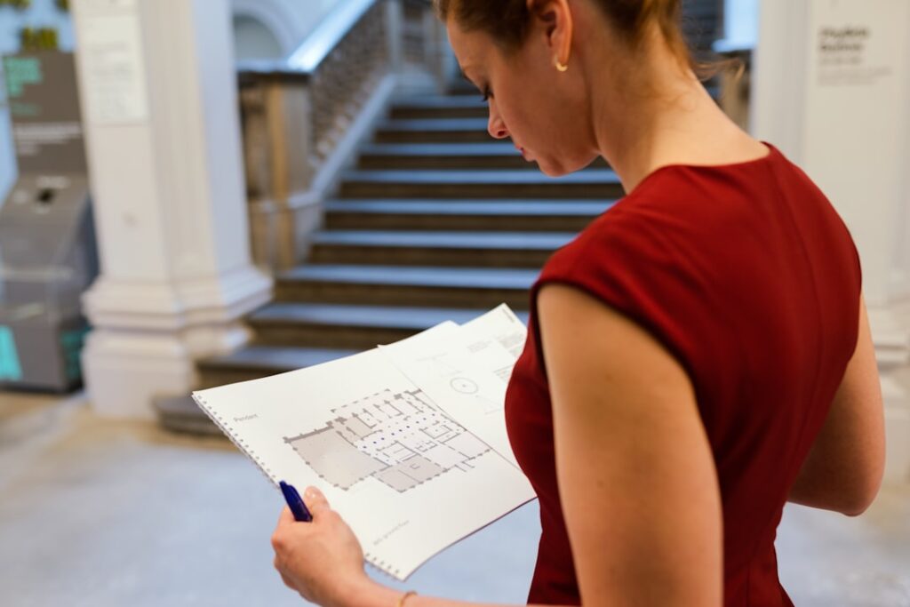 Professional woman with a concerned expression reads an official letter in her brightly lit home office, representing the ...