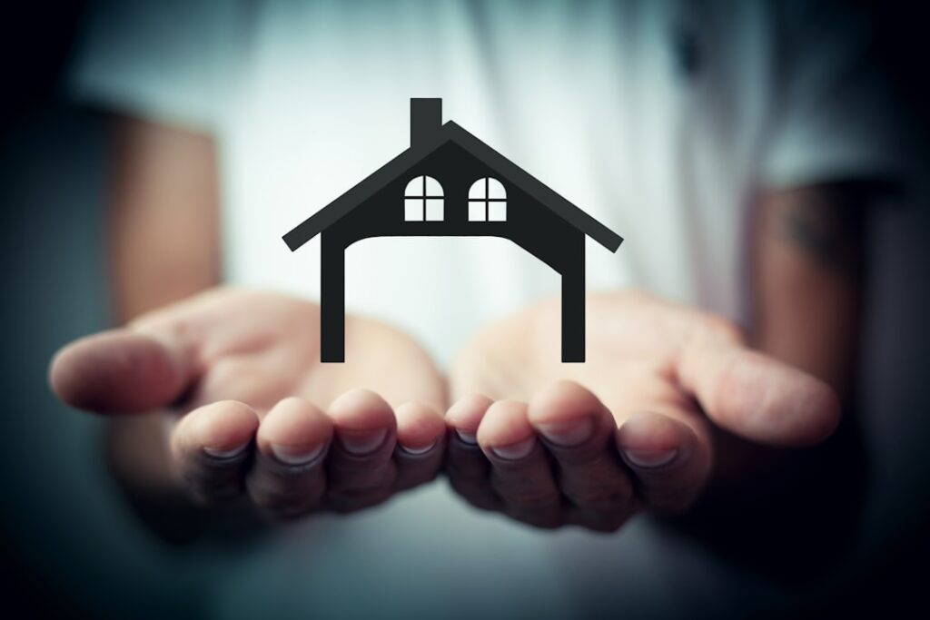 Close-up of a person's hands holding two distinct house keys, symbolizing the choice between different real estate commiss...