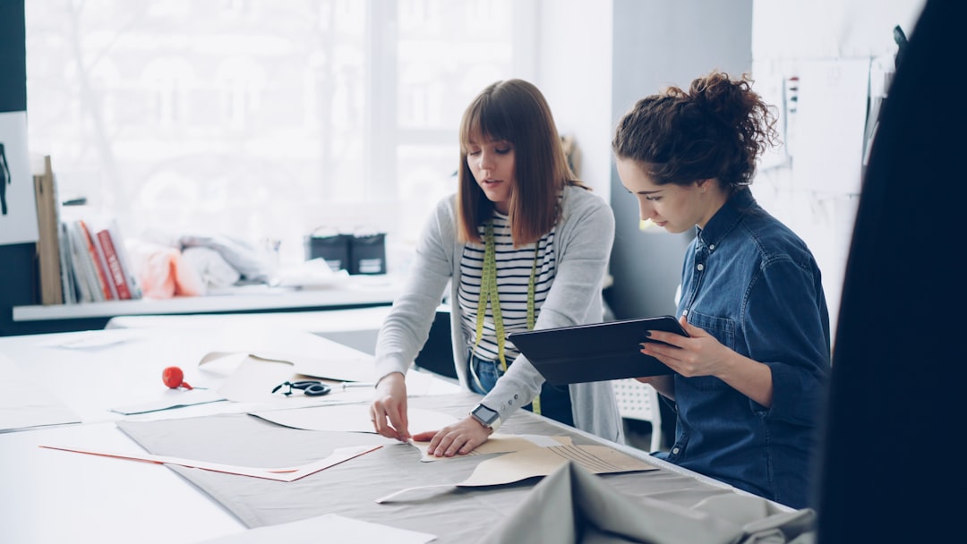 Female real estate agent in a bright, modern office thoughtfully reviews paperwork, representing the careful decision of c...
