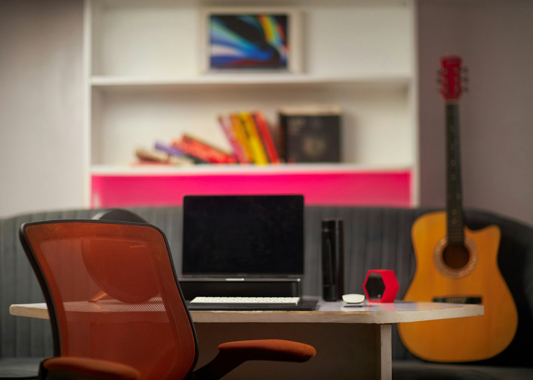 A clean and modern desk setup featuring a laptop and a set of house keys, symbolizing the integration of AI technology in the real estate industry.