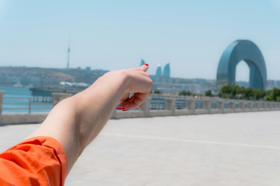 A close-up of a hand pointing to a location pin on a digital map displayed on a screen, illustrating the use of AI for dominating local search.