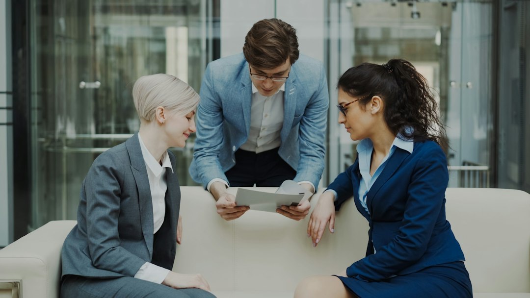 Professional real estate agent sits in a bright, modern living room, using a tablet to manage her business with AI-powered...